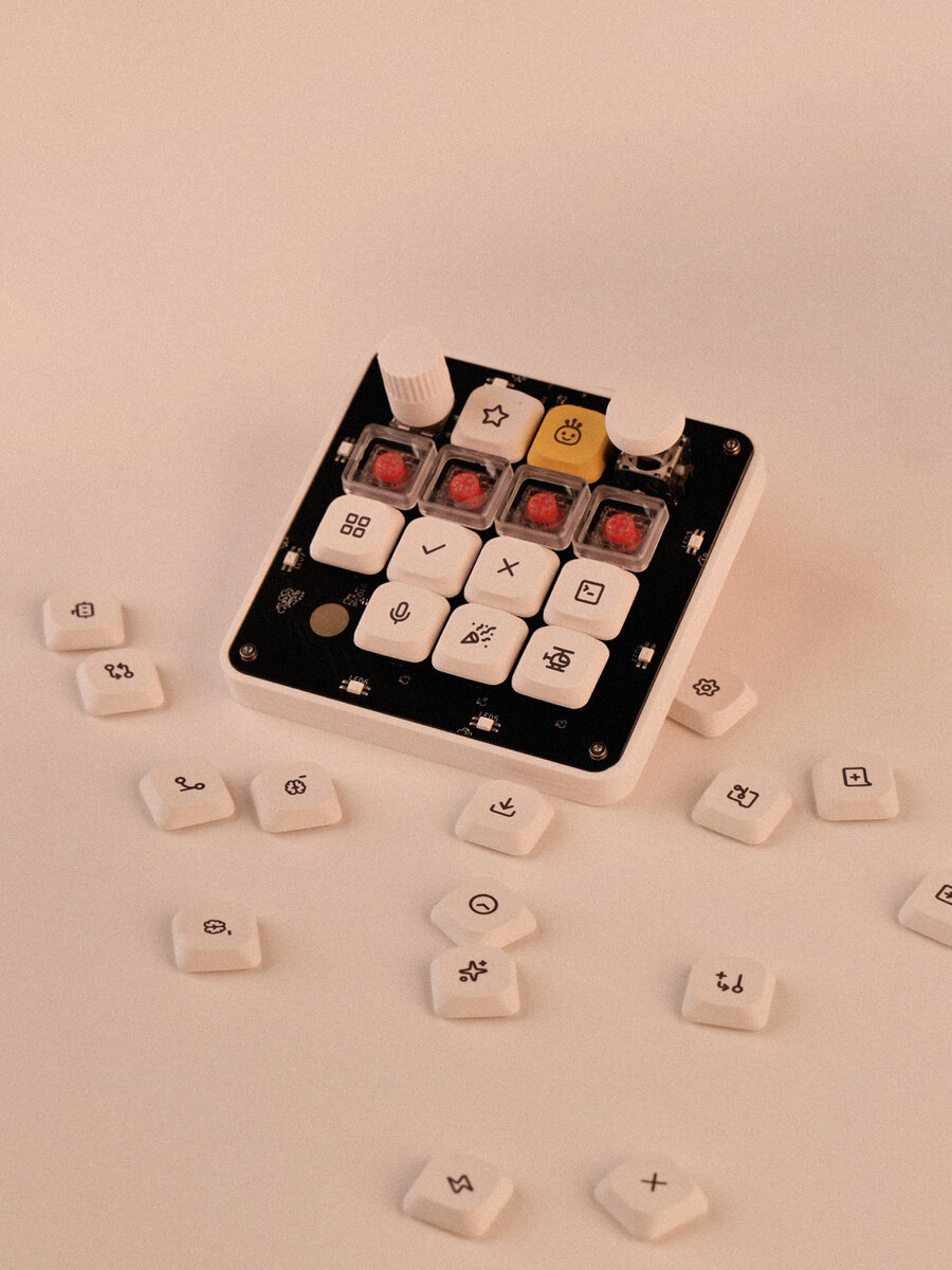 The board surrounded by loose engraved keycaps, each carrying a different legend